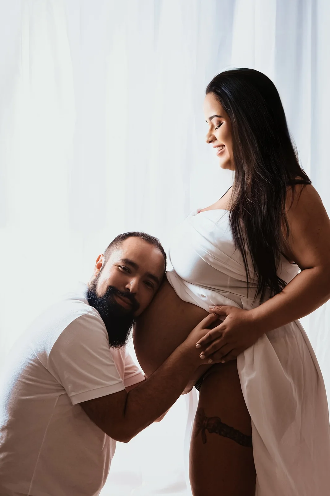 Pai participando do ensaio gestante com carinho na barriga