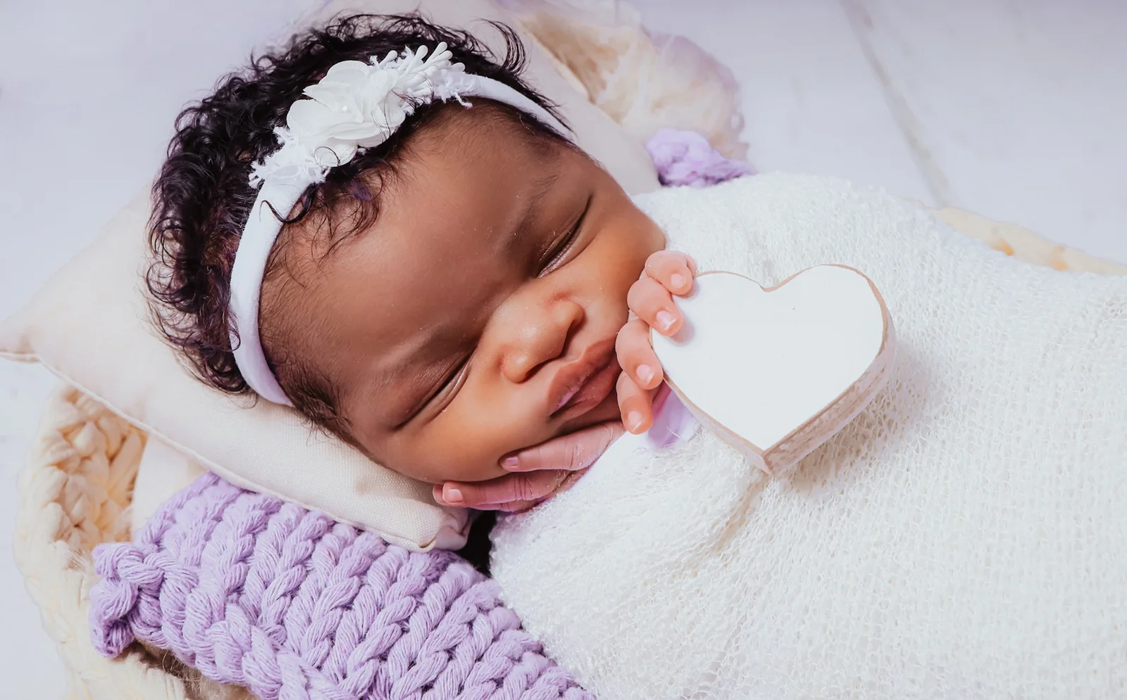 Close de bebê em ensaio newborn delicado com tons claros