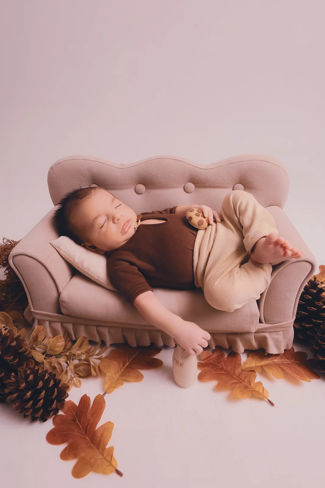 Ensaio newborn em tons terrosos com bebê em mini sofá