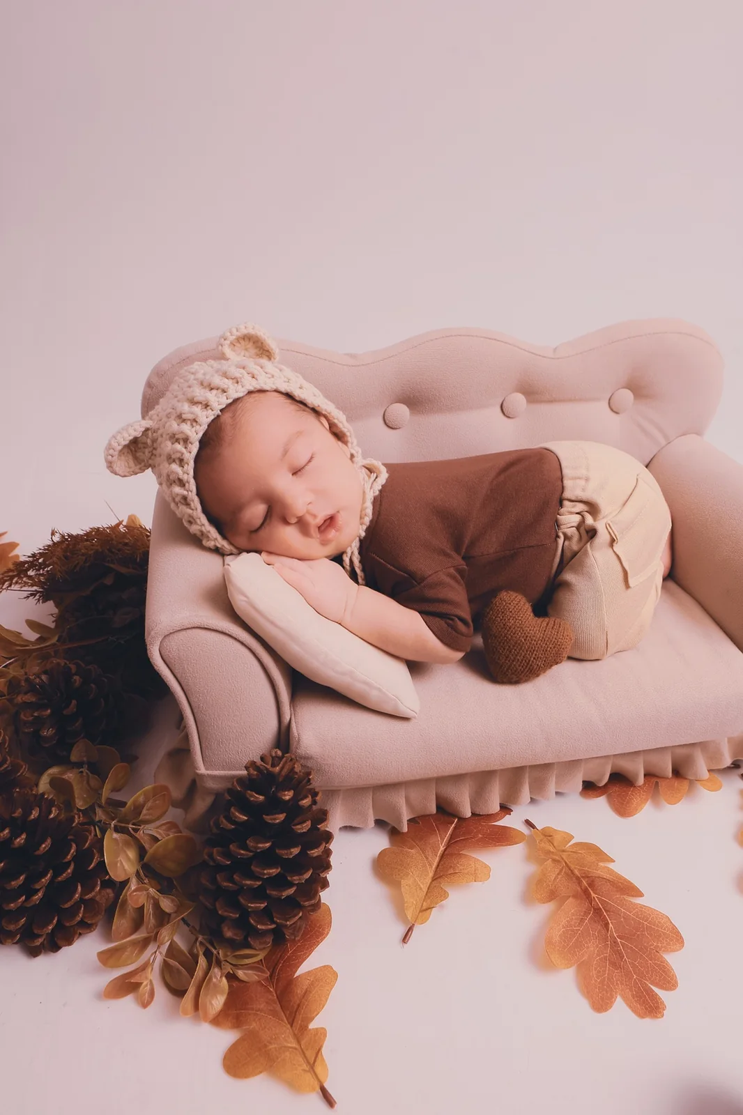 Bebê dormindo em produção newborn acolhedora em tons de caramelo